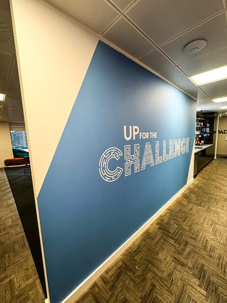 An image of the blue "Up for the Challenge" wall graphic.
